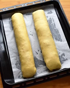 two long loafs of bread sitting on top of a pan