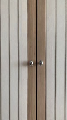 a close up of a wooden door with two knobs on the front and side