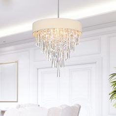 a chandelier hanging from the ceiling in a dining room with white walls and chairs