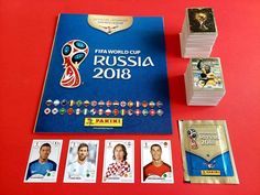 the official cards for the 2018 world cup are displayed on a red table with other items