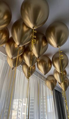 many gold balloons are hanging from the ceiling