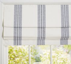 a window with blue and white striped roman blinds