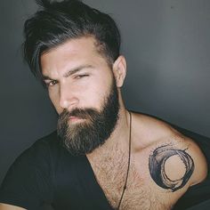 a man with a beard and tattoos on his chest