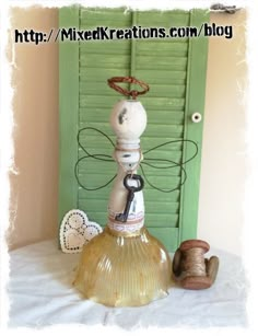 a glass bottle sitting on top of a table next to a spool of thread