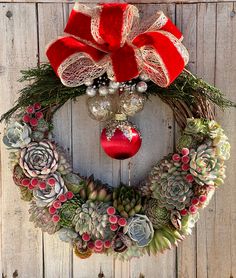 a christmas wreath hanging on the side of a wooden door with ornaments and decorations around it