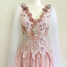 a pink and white dress on a mannequin headdress with lace detailing