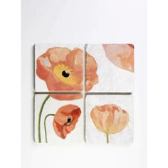 four square tiles with flowers painted on them