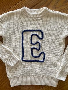 a white sweater with the letter e on it