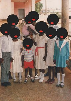 a group of people standing next to each other in front of a building with black circles over their faces