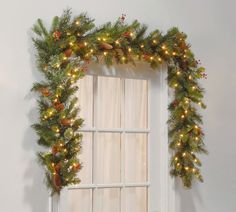 a window decorated with christmas garland and lights