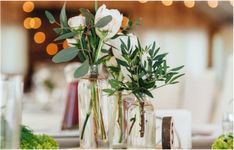 three vases filled with flowers on top of a table