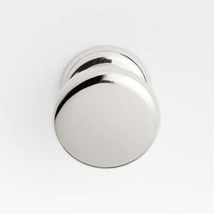 three round knobs on a white wall, one with black trim and the other without