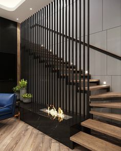 a blue chair sitting in front of a fire place next to a wooden stair case