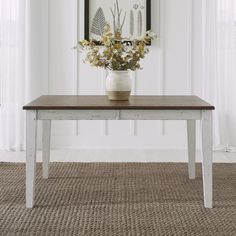 a vase with flowers sitting on top of a wooden table