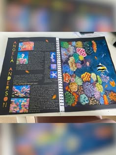 an open book with images of fish and corals