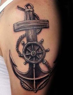 an anchor and steering wheel tattoo on the back of a woman's shoulder,