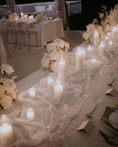 a long table with white flowers and candles