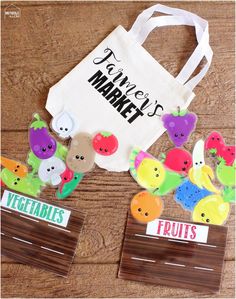 a bag and some fruit magnets sitting on a table next to a paper bag