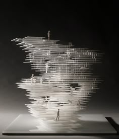 an abstract sculpture with people standing on it's sides and stacked books in the middle