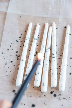 a person is lighting candles with a lighter in front of them on a piece of paper