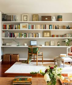 a living room filled with furniture and bookshelves covered in lots of bookcases