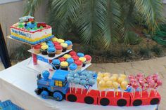 a train cake and cupcakes on a table