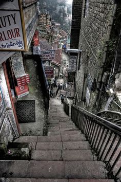 an alleyway with stairs and signs on the buildings