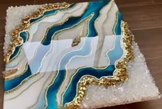 a piece of art that looks like it has been painted with gold and blue paint