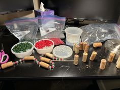 some wine corks are sitting on a table next to other bottles and containers with beads