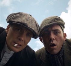 two men are posing for the camera with their hats on and one man has his mouth open