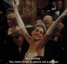 a woman wearing a tiara and holding her arms in the air