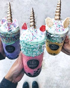 three unicorn milkshakes with sprinkles and toppings