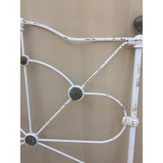 an old white metal bed frame with black knobs