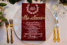 a place setting with red napkins and gold cutlery