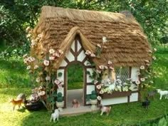 a small house with flowers and plants on the roof is shown in this miniature garden