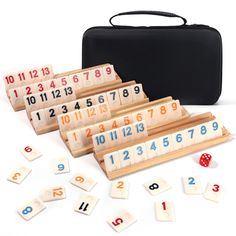 several wooden numbers and dices in front of a black case on a white surface