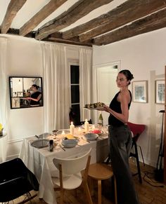 a woman standing in front of a table with food on it