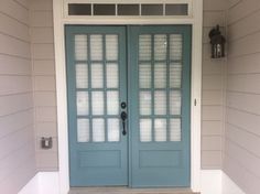 a blue front door with two sidelights and glass panels on the top half of it