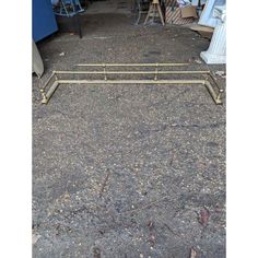 a metal bed frame sitting in the middle of a parking lot next to other items