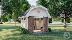 a small white shed sitting on top of a lush green field