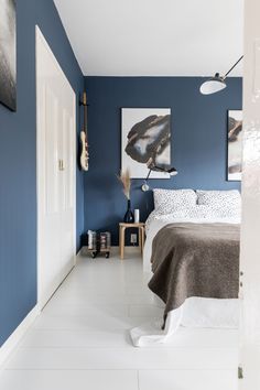 a bedroom with blue walls and white floors