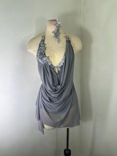 a mannequin wearing a gray top with silver sequins on the neck