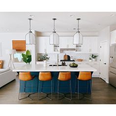 a kitchen with an island and four stools in front of the countertop area