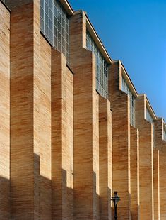 the side of a building that is made out of wood and has many windows on it