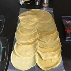 a stack of tortillas sitting on top of a table next to other food items