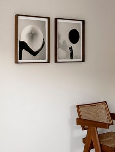 two framed pictures hang on the wall next to a wooden chair and wicker chair