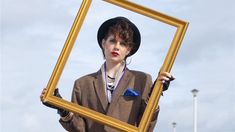 a woman holding up a framed photo in front of her face with the words the movie sing street 2016 below it