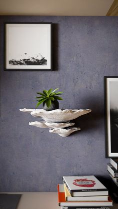 a vase with a plant in it sitting on top of a table next to books