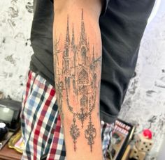 a man with a tattoo on his arm that has a castle in the middle of it