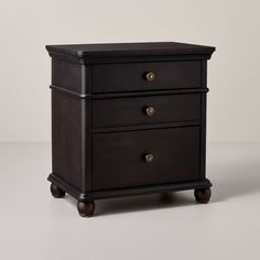 a black nightstand with two drawers on wheels